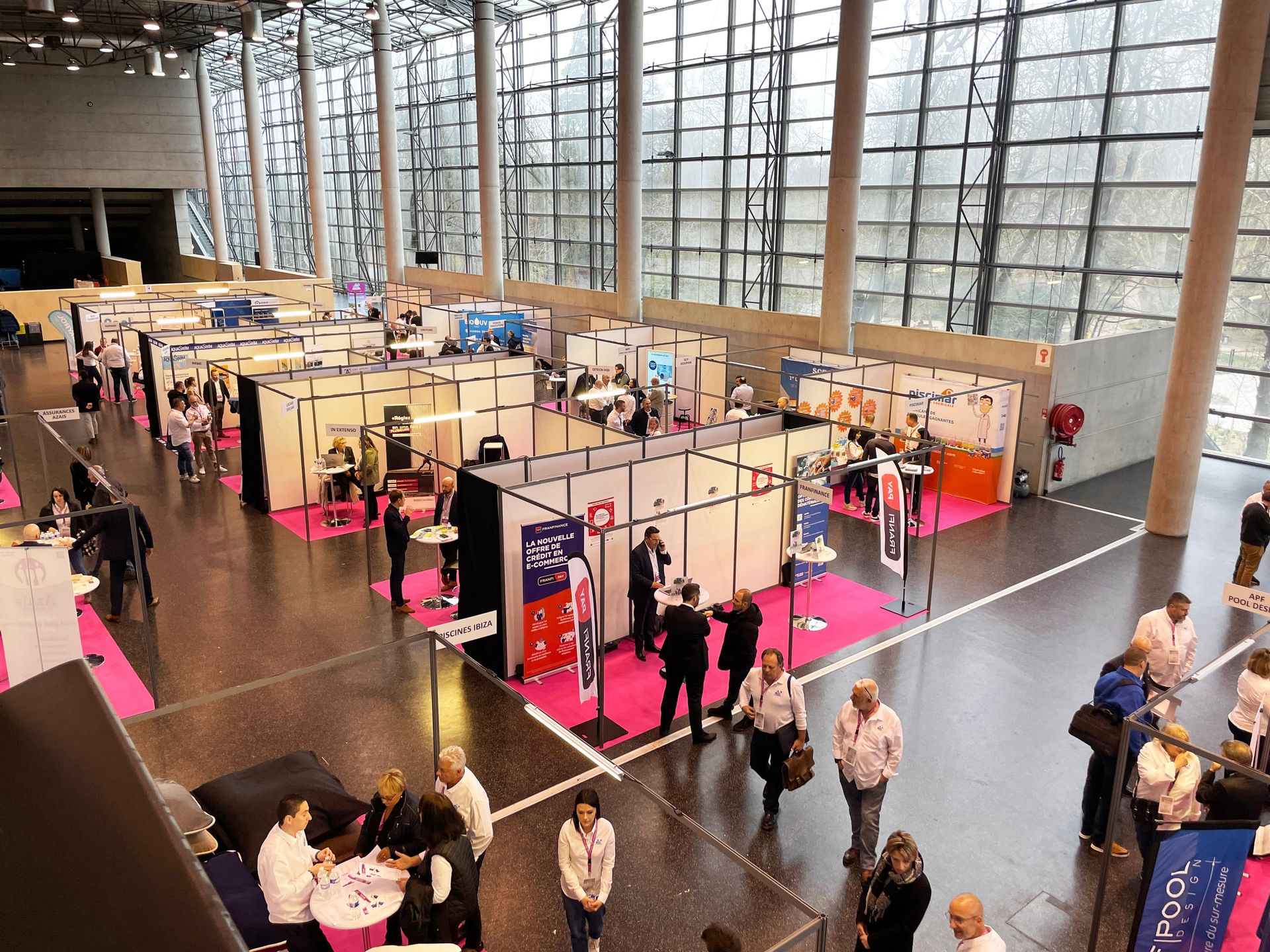Salon partenaires avec stands dans un hall lumineux
